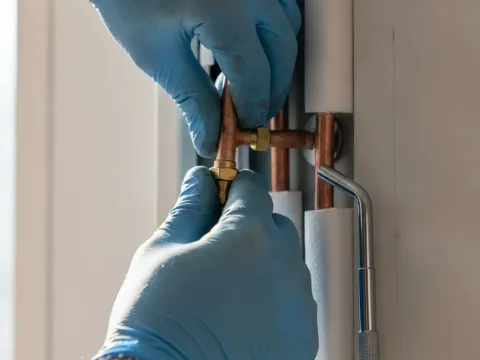 Close-up of copper line set connection during mini-split installation in Aubrey