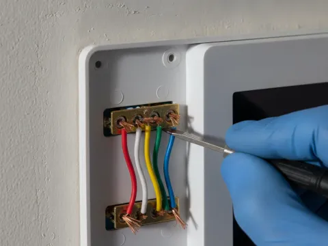 Close-up of thermostat wires connected to terminals during Aubrey HVAC install